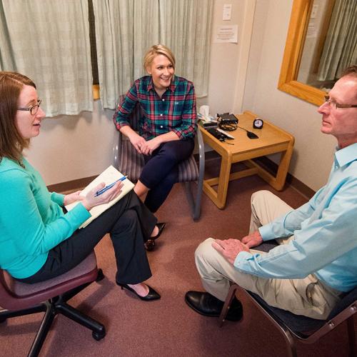 Three individuals sit in a room in a counseling session