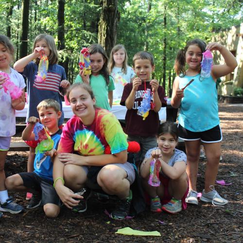 Group of campers hold up their craft project