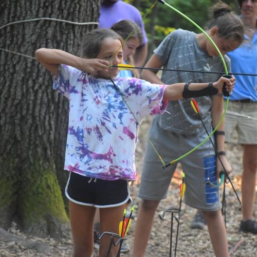 A girl shoots a bow and arrow
