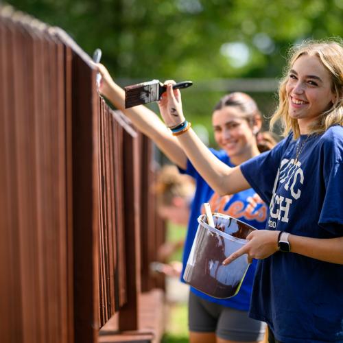 Students painting a fence on humanics in action