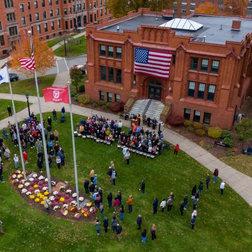 The Springfield College community participates in Veterans Day Observance on the steps of Marsh Memorial Hall 