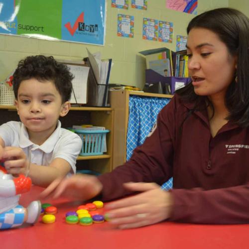 AmeriCorps member working with a young student