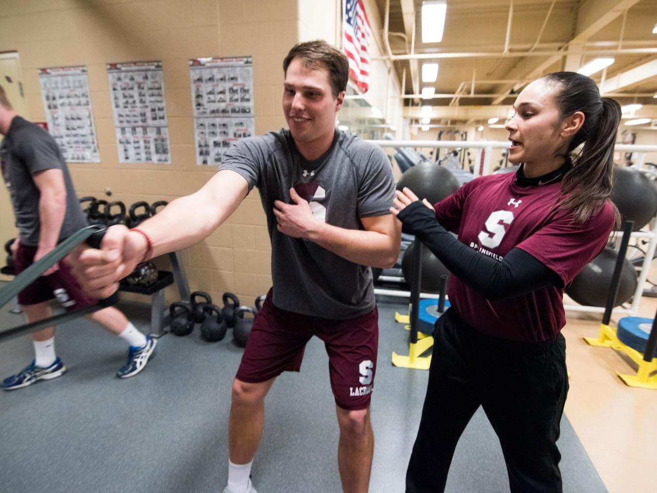 A strength and conditioning student trains another student in our on-campus strength and conditioning facility.