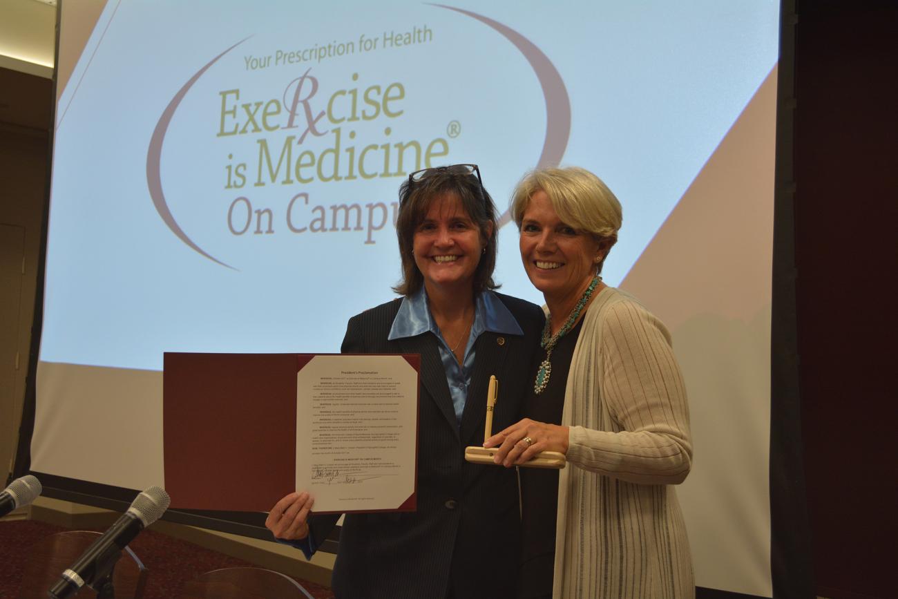 As part of the Joint Speaker Series, Springfield College President Mary-Beth Cooper, right, proclaims October as Exercise is Medicine on Campus month with a special proclamation ceremony with Springfield College Department of Exercise Science and Sport Studies Chair Dr. Sue Guyer.