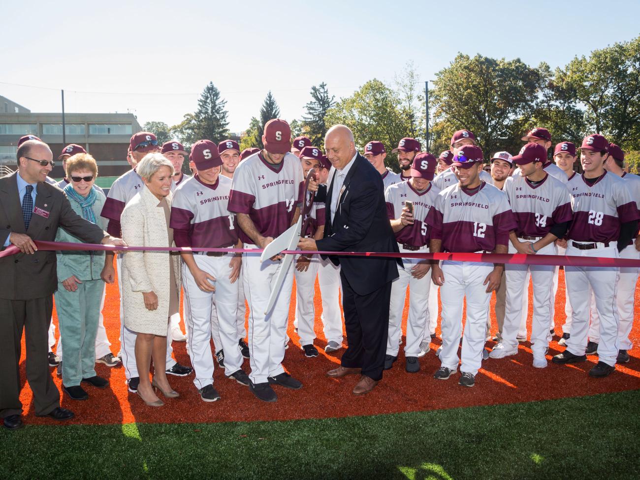 The Springfield College Men's baseball team, college leaders, and Cal Ripken Jr. join together to cut the ribbon on the new adaptive field.