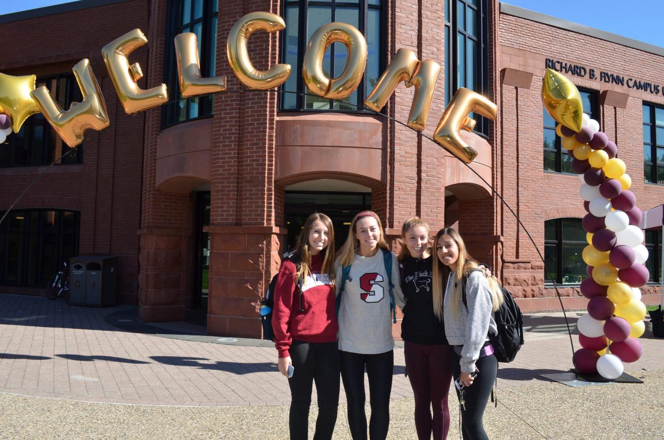 Group of students standing outside the Union with welcome balloons.