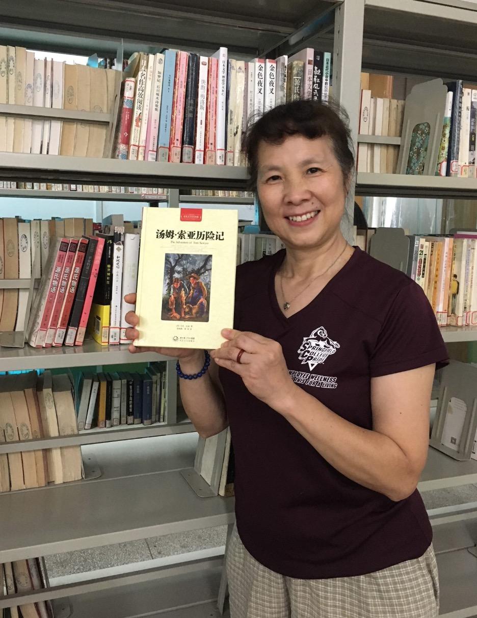 Cathy Xu holds a copy of Tom Sawyer in her native Chinese language. 