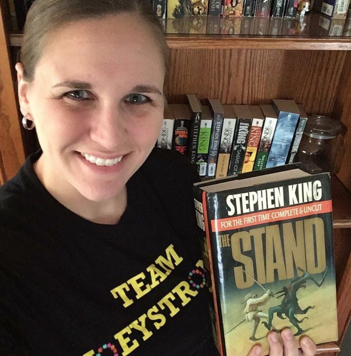 Outreach Librarian Kerri Vautour holding a copy of Stephen King's The Stand. 