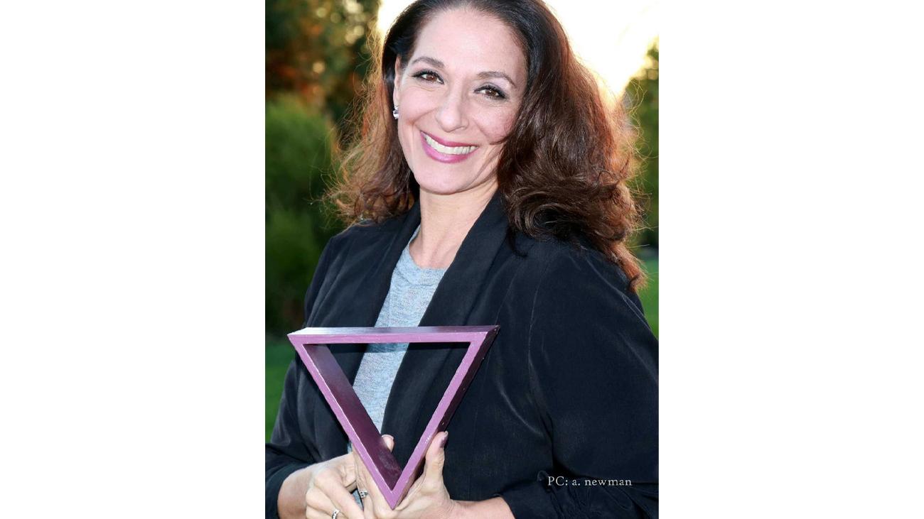 Marianna Newman holding a triangle. 