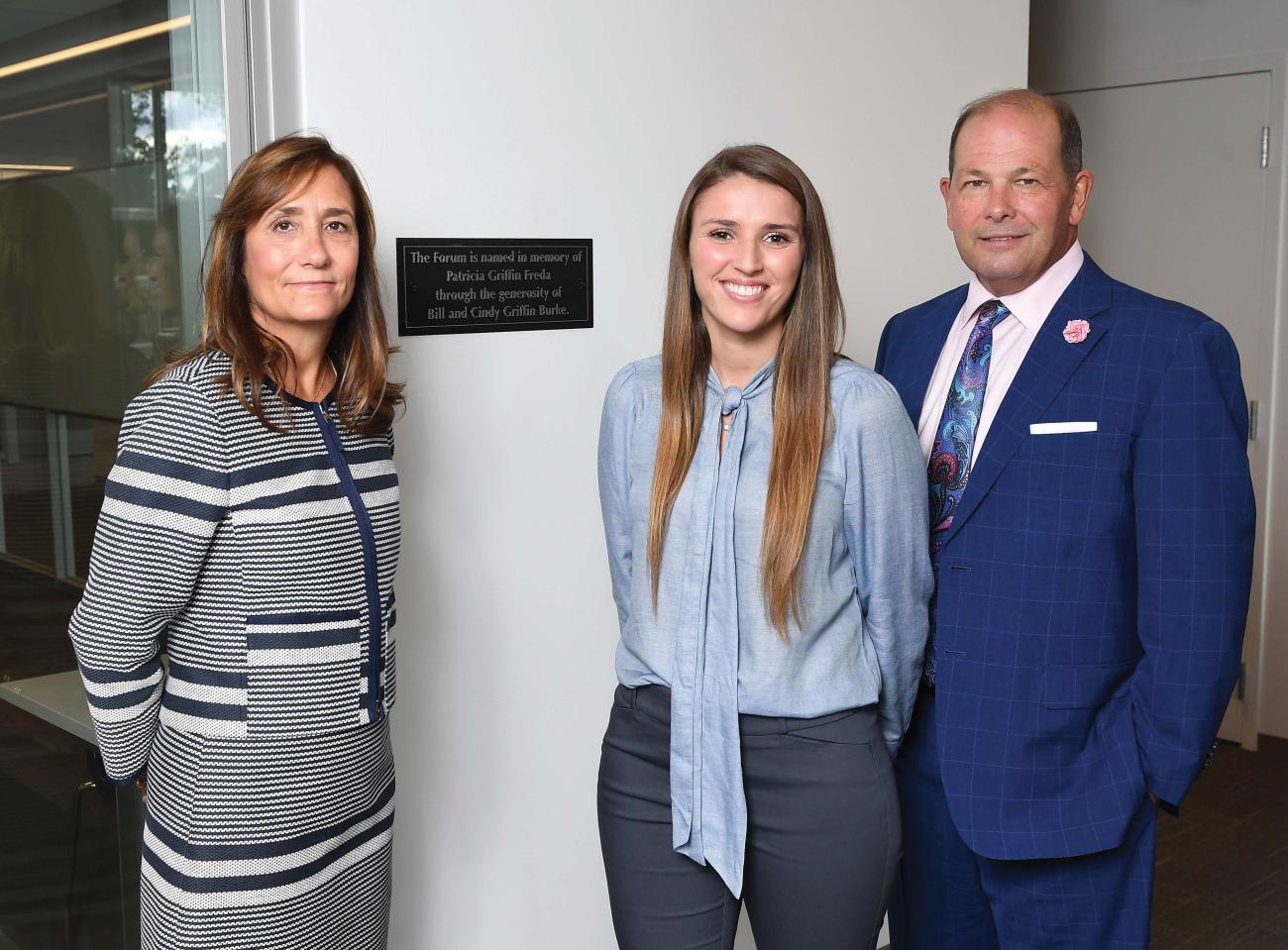 Cindy Burke, from left, Avery Pedro, and Bill Burke meet in the Learning Commons near the plaque dedicating The Forum to Cindy’s mother.