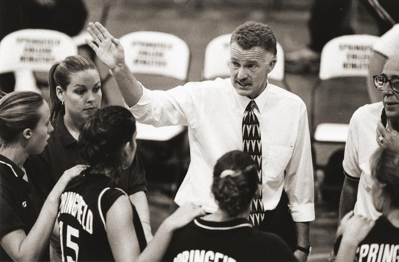 an old sepai tone photo of Joel Dearing coaching women's volleyball student-athletes