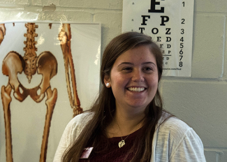 student with anatomy poster