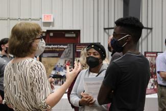 A faculty member speaks with students
