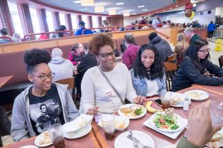 A family enjoys lunch in the dining hall at Springfield College