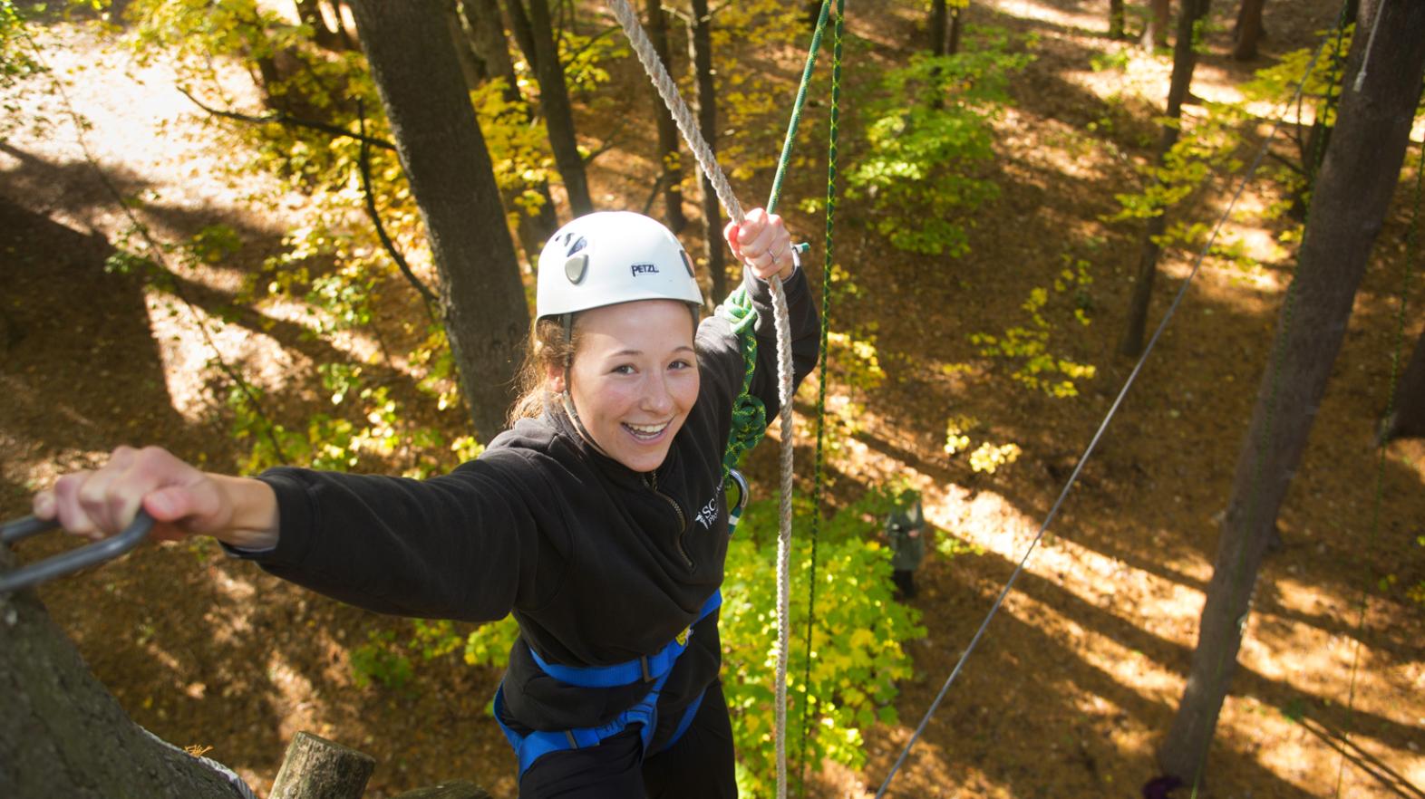 A student does the ropes course at East Campus