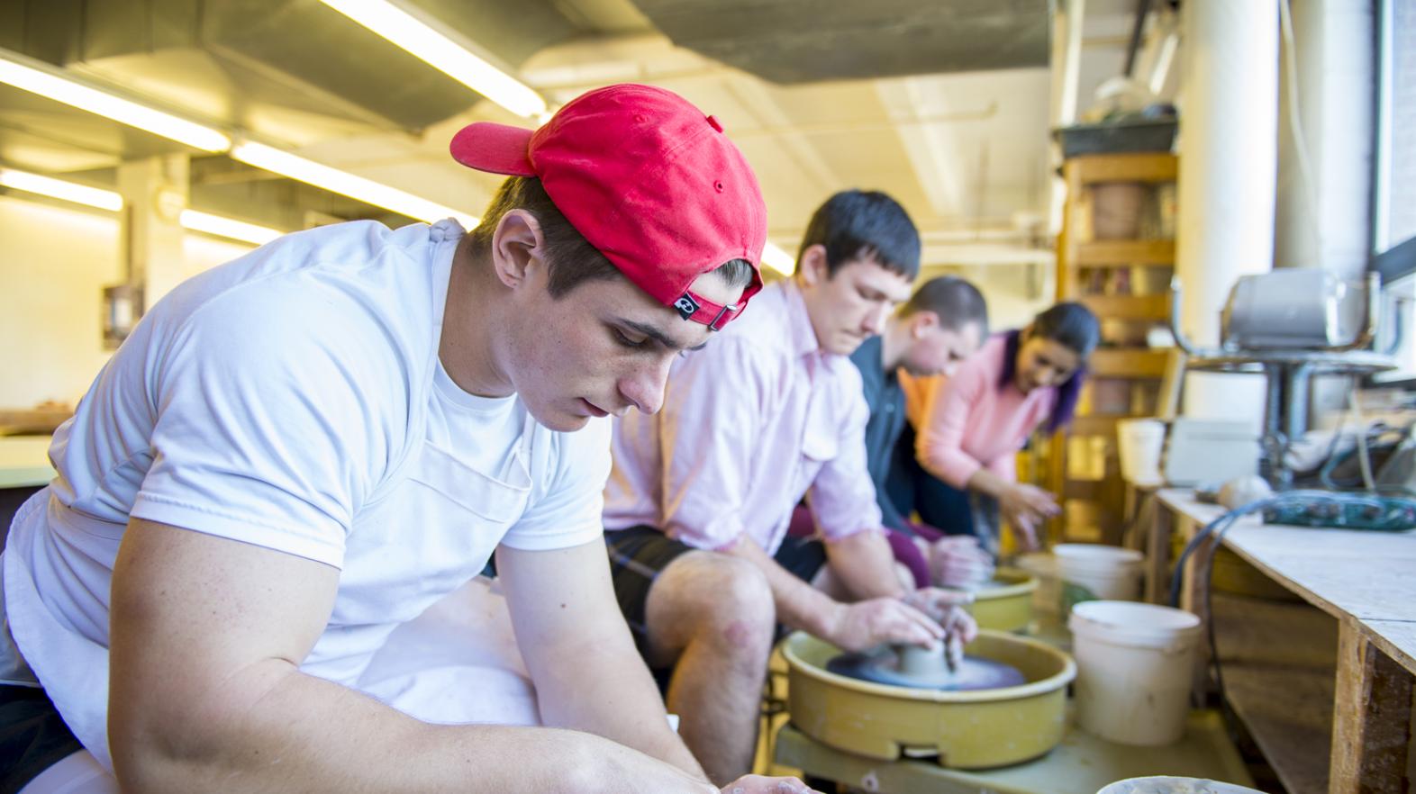 A student works in a studio on some pottery