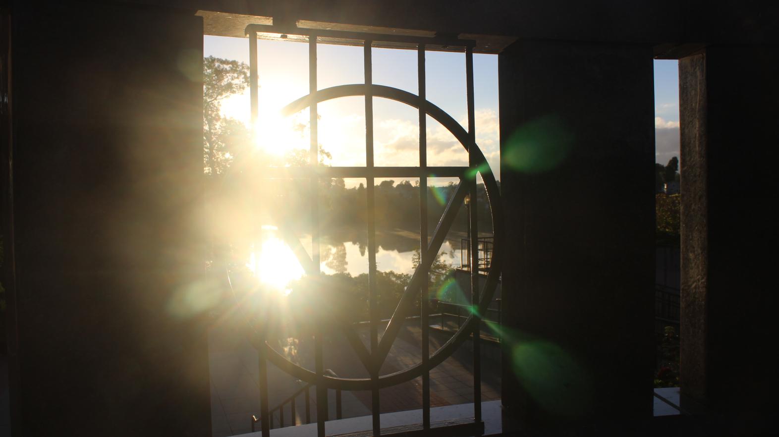 Our Gulick triangle frames the sun rising over Lake Massasoit in this photograph from graduate student Paige Moran.