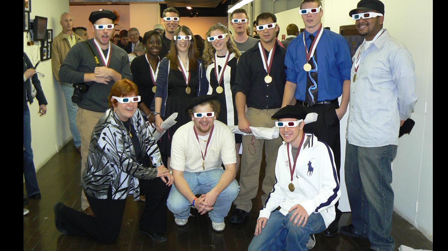 Students and Professor Ruth West pose in 3D sunglasses after a presentation using 3D technology during the annual senior art show.