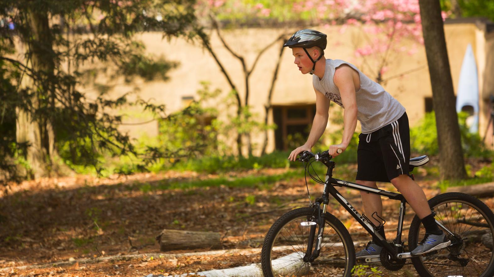 Student bikes at East Campus on the trails during Outdoor Pursuits at Springfield College