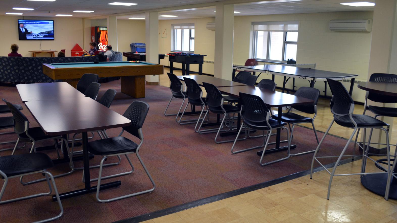 The common area in Massasoit residence hall, complete with dining area and TV area.
