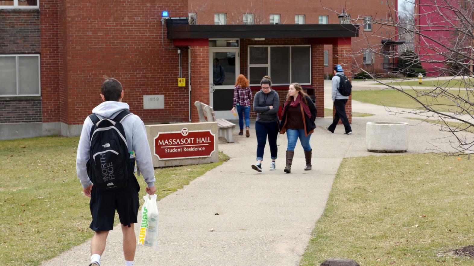 The front of Massasoit Hall with students walking into the building.