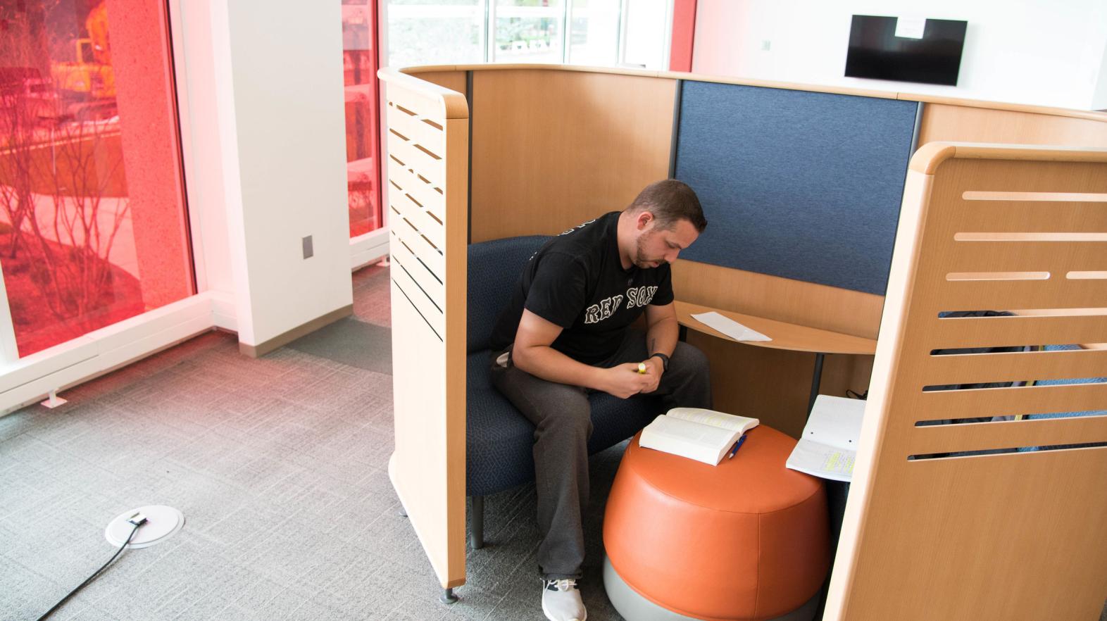 A male student studies in a study nook in the Harold C. Smith Learning Commons.