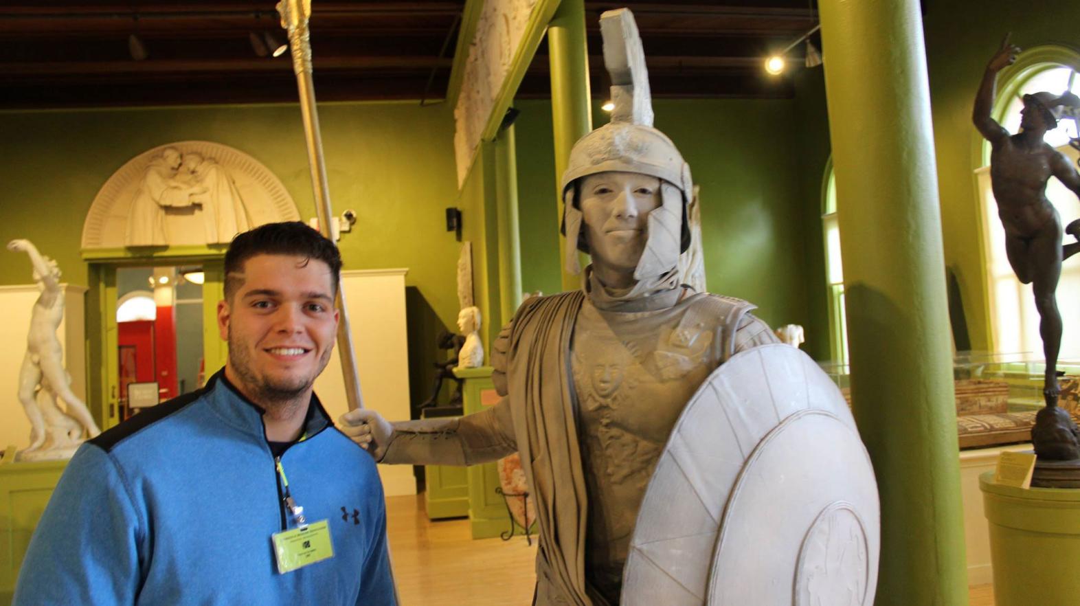 Hogan Tomkunas poses with a statue at his internship.
