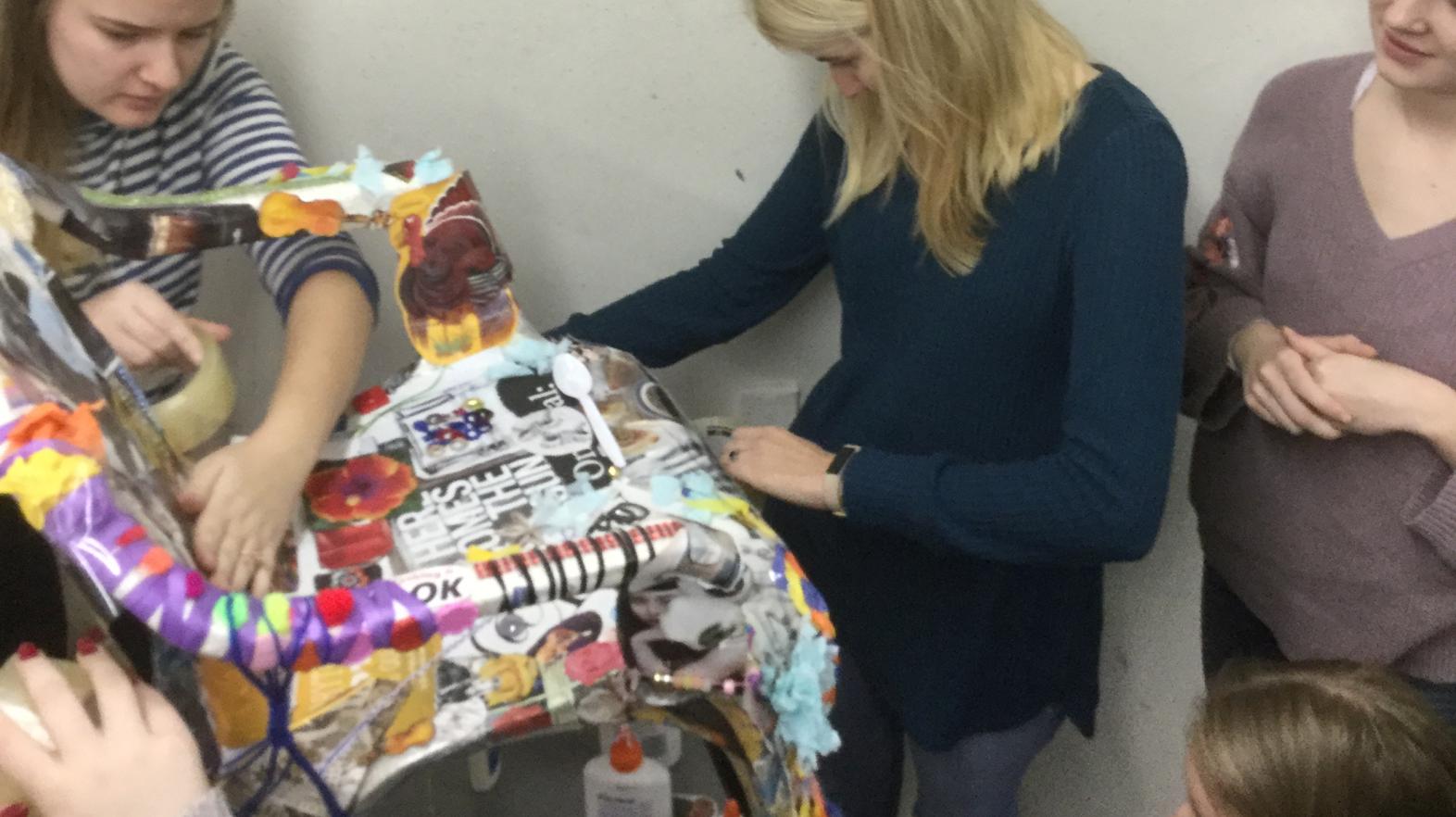 Art therapy students work together on a chair.