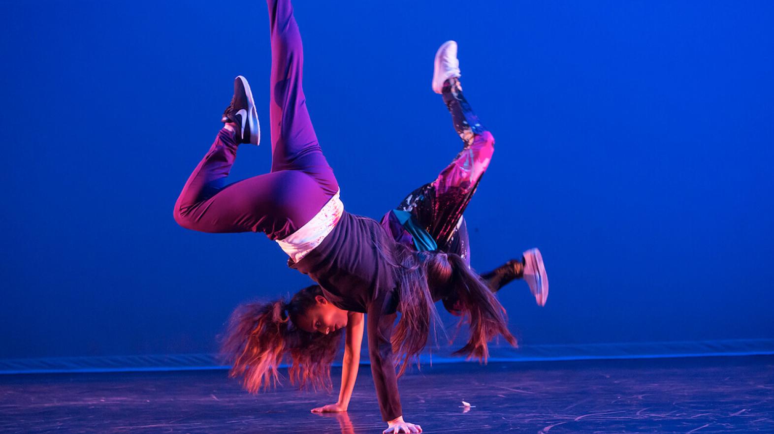 Two dancers perform a hip hop routine