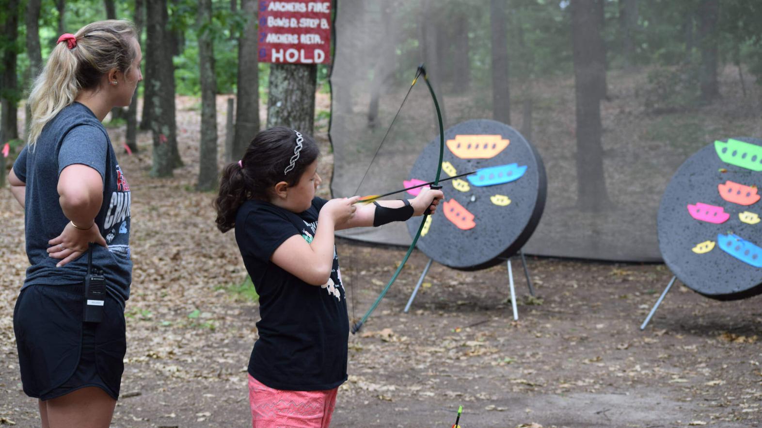 Camper shoots a bow and arrow.