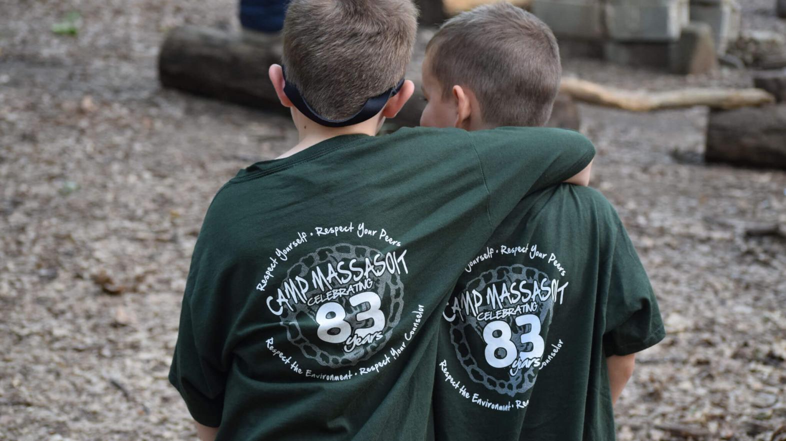 Two campers with their arms around one another. 