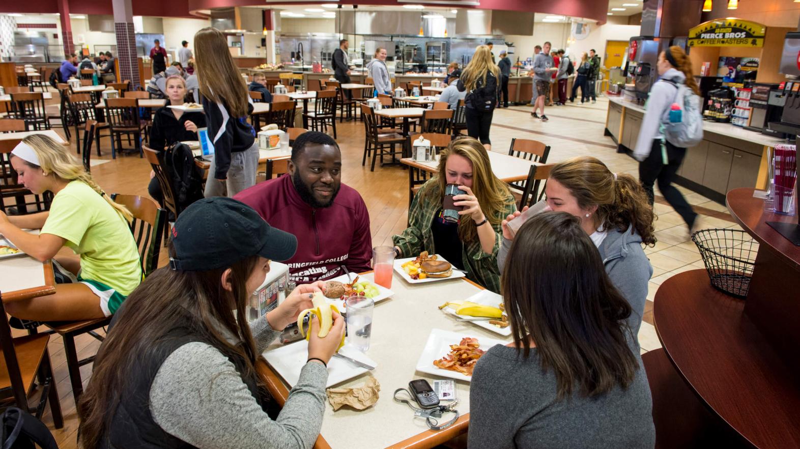 Students sit at a table and eat in Cheney Cafeteria. 