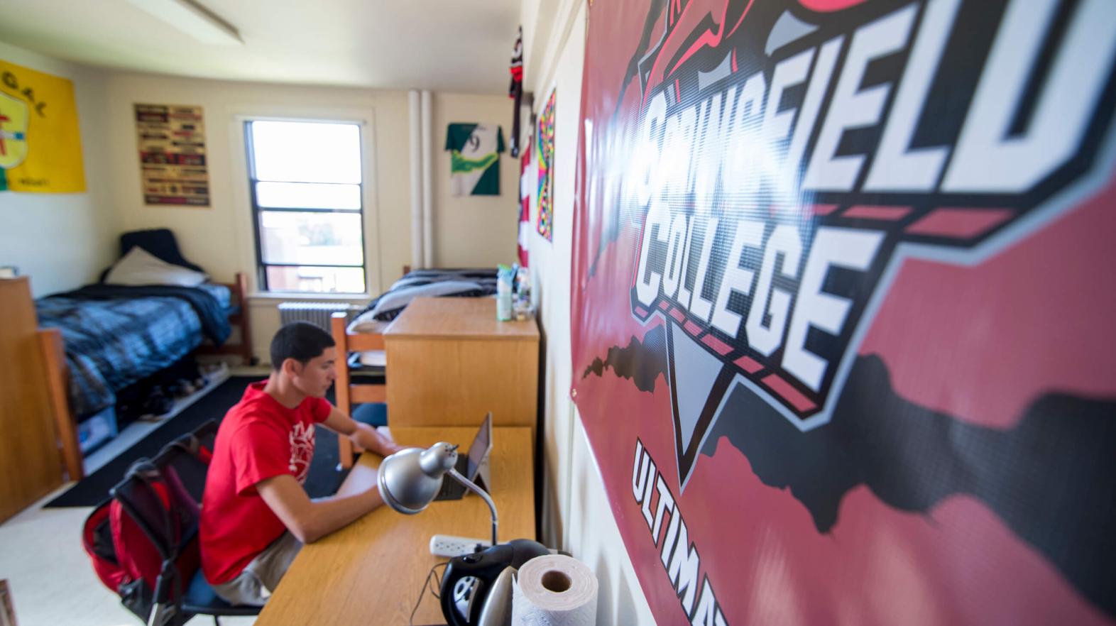 A student sits on his computer in one the residence halls. 