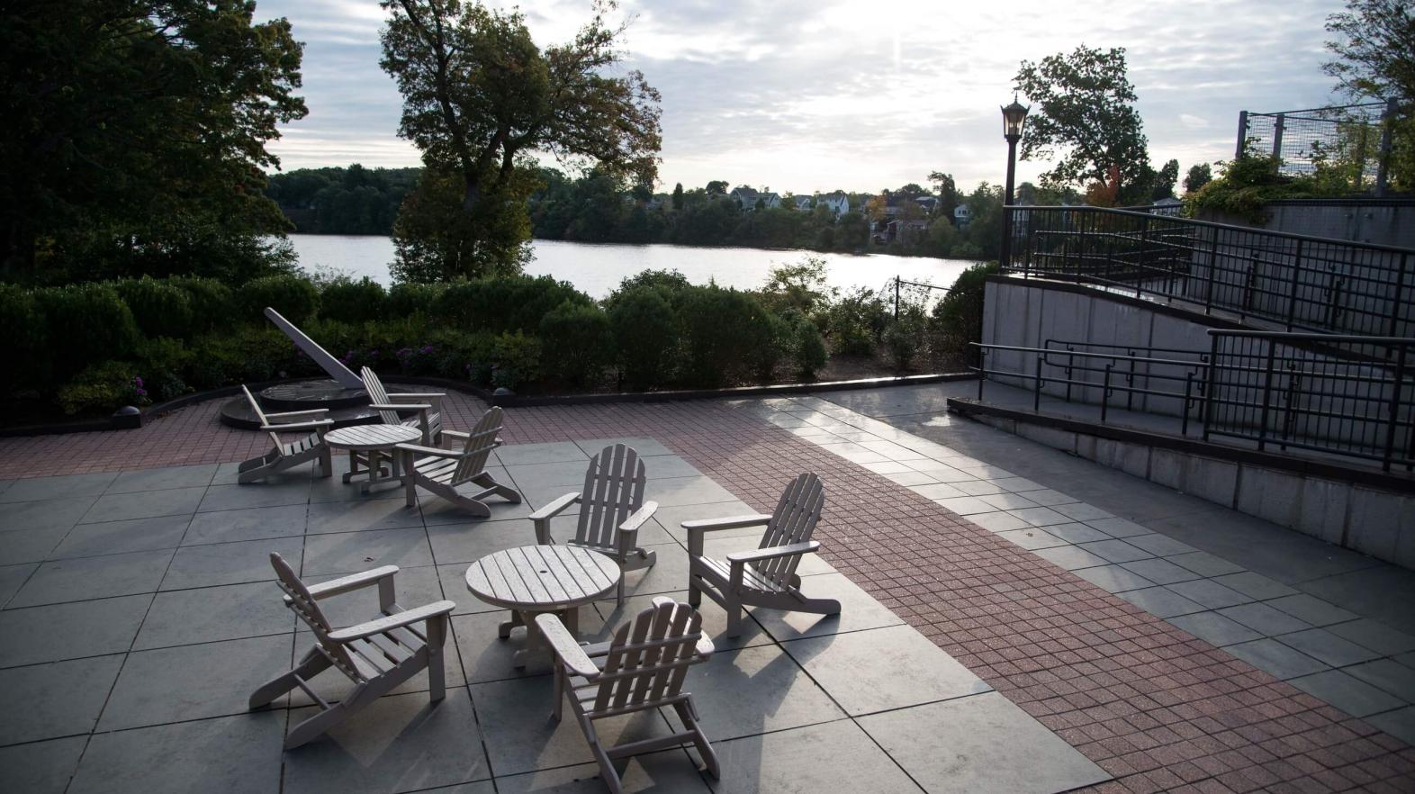 A view with chairs and tables overlooking Lake Massasoit. 