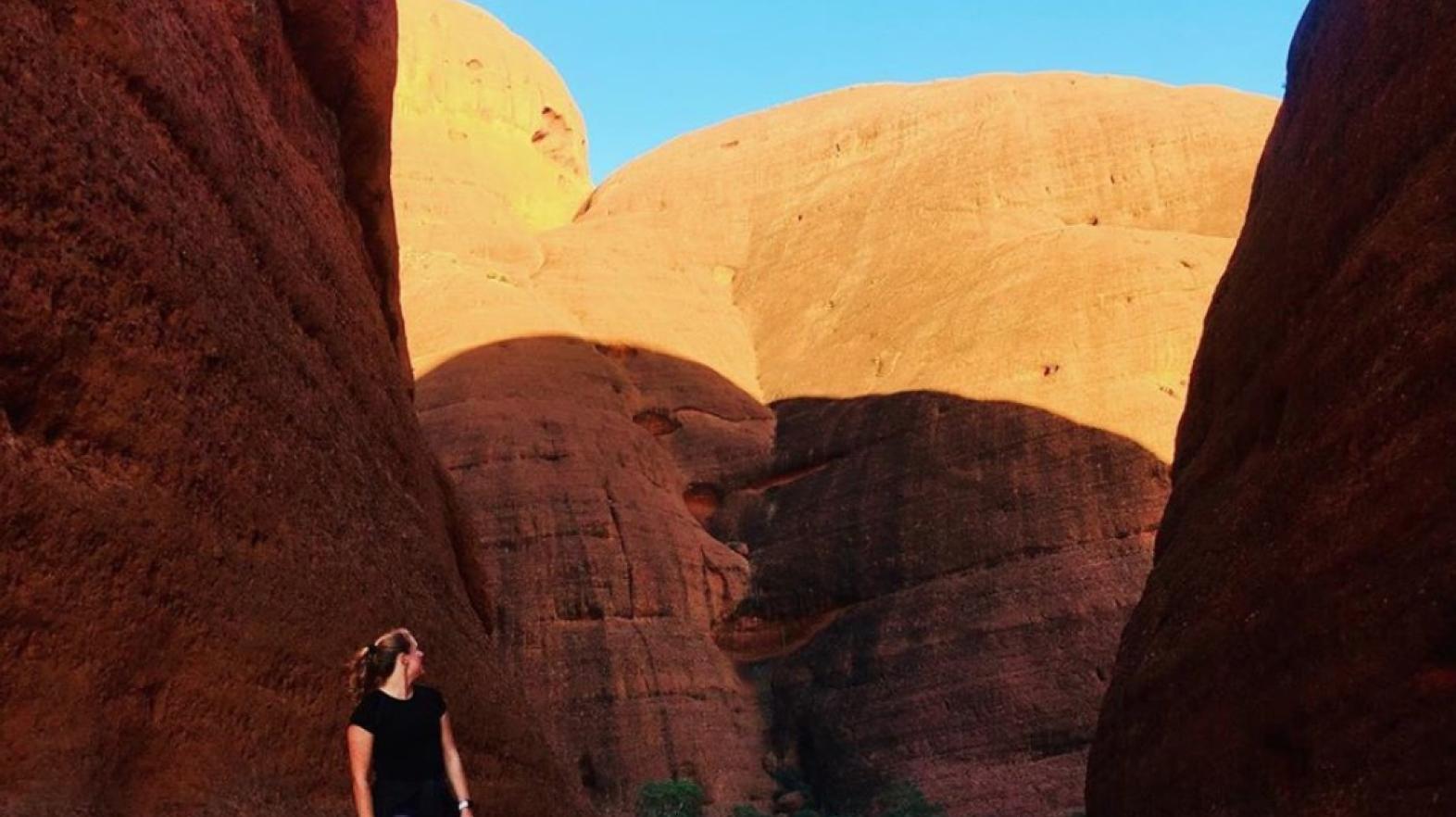 A study abroad student stands in front of a canyon. 