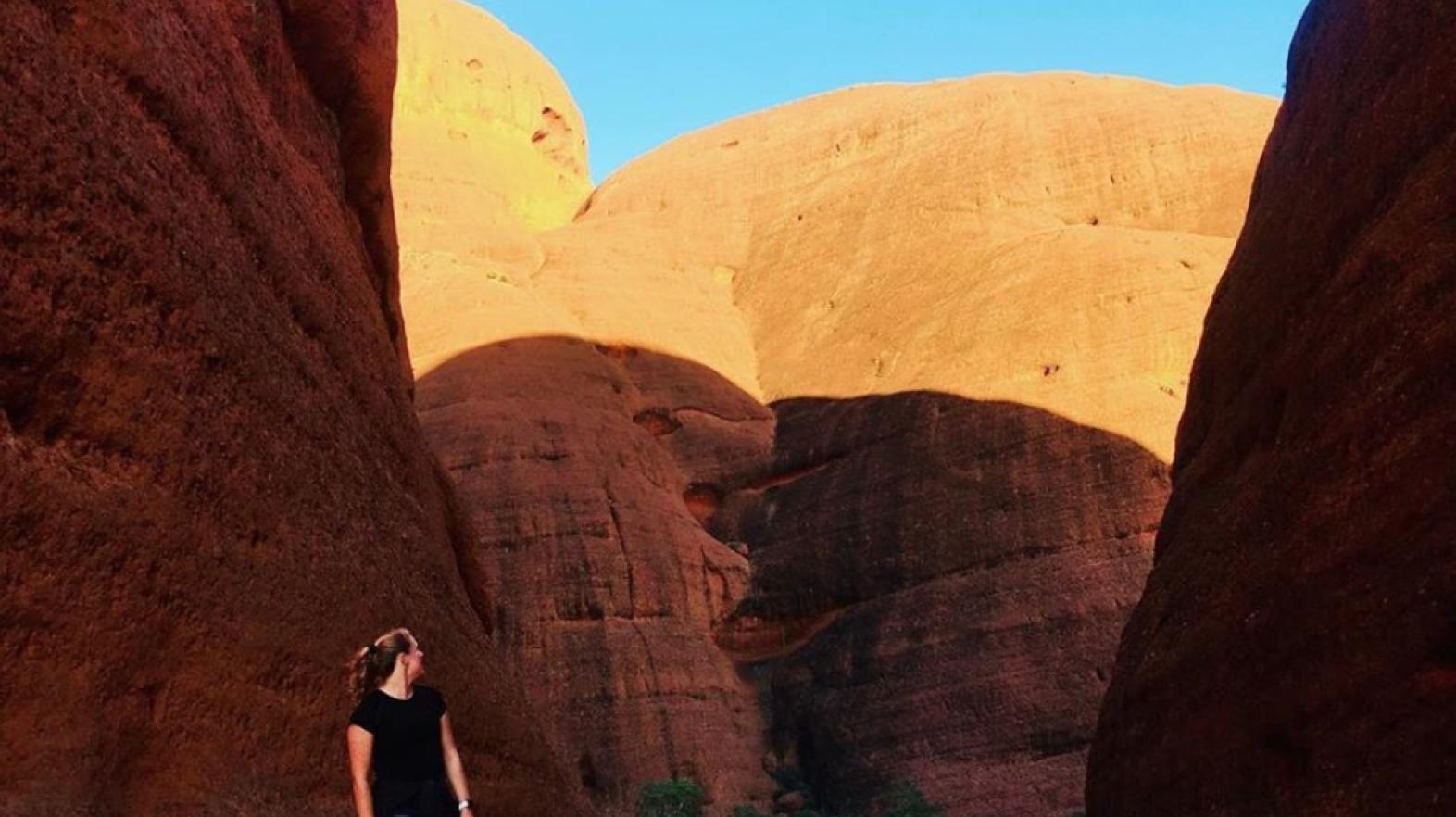 A study abroad student stands in front of a canyon.