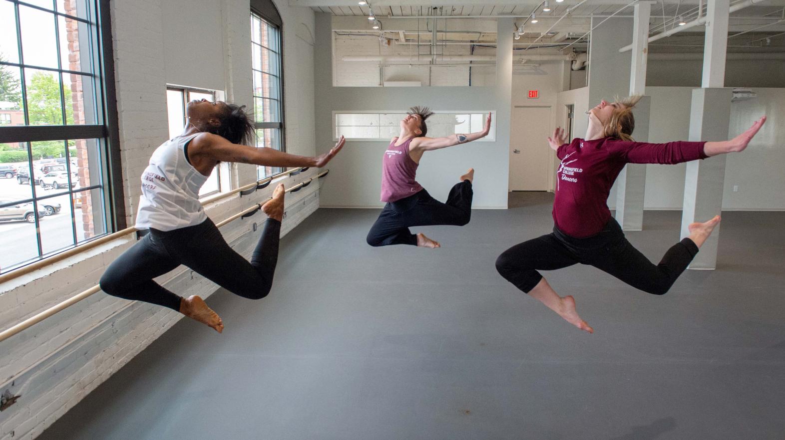 Group of dancers leap in the studeio