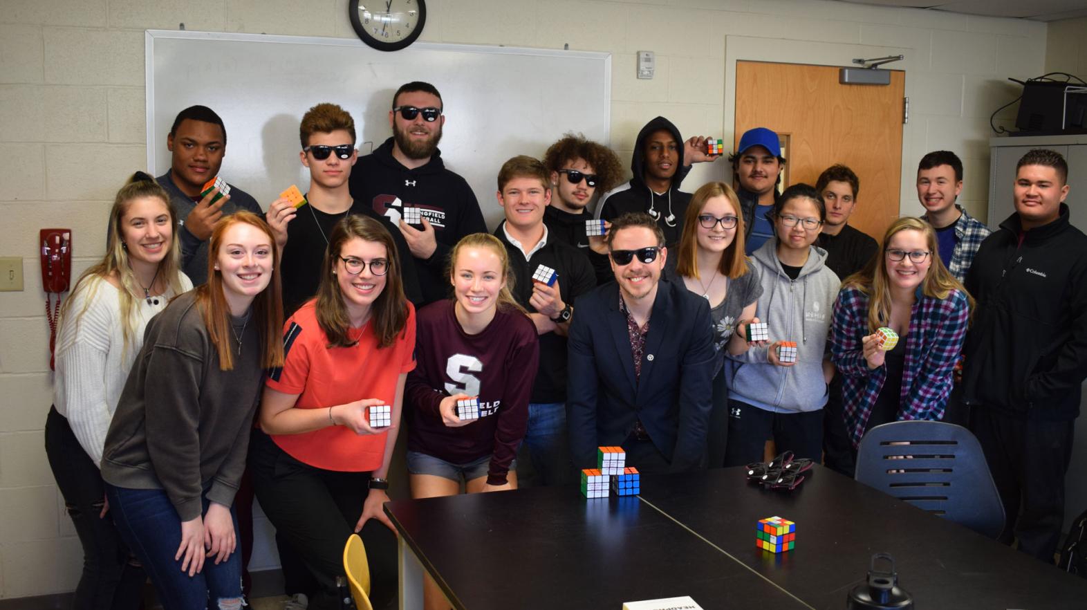 A group of students from the Springfield College Department of Mathematics, Physics, and Computer Science stand together at a Rubik's Cube competition