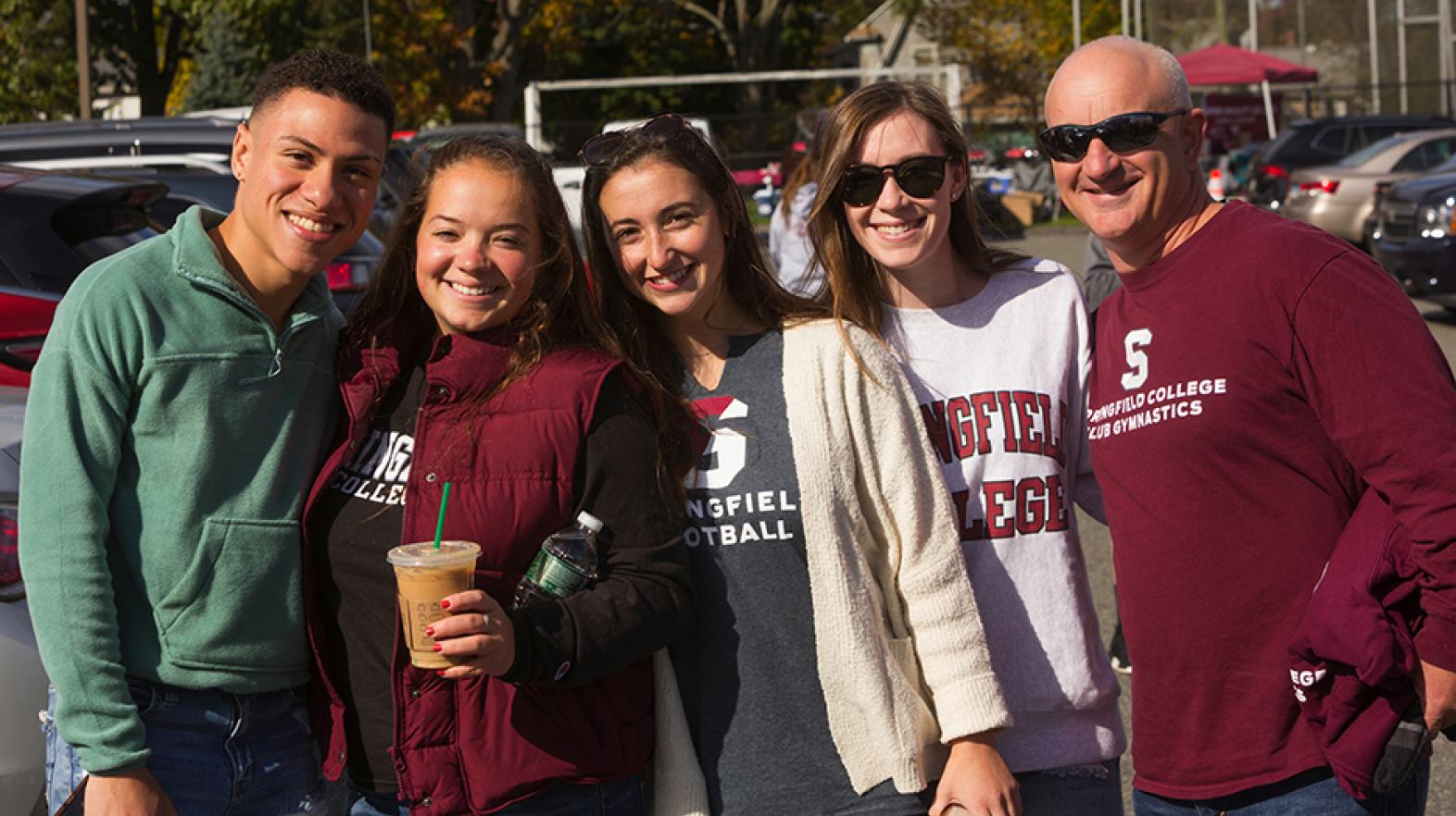 a group of younger and older alumni gathered for tailgating