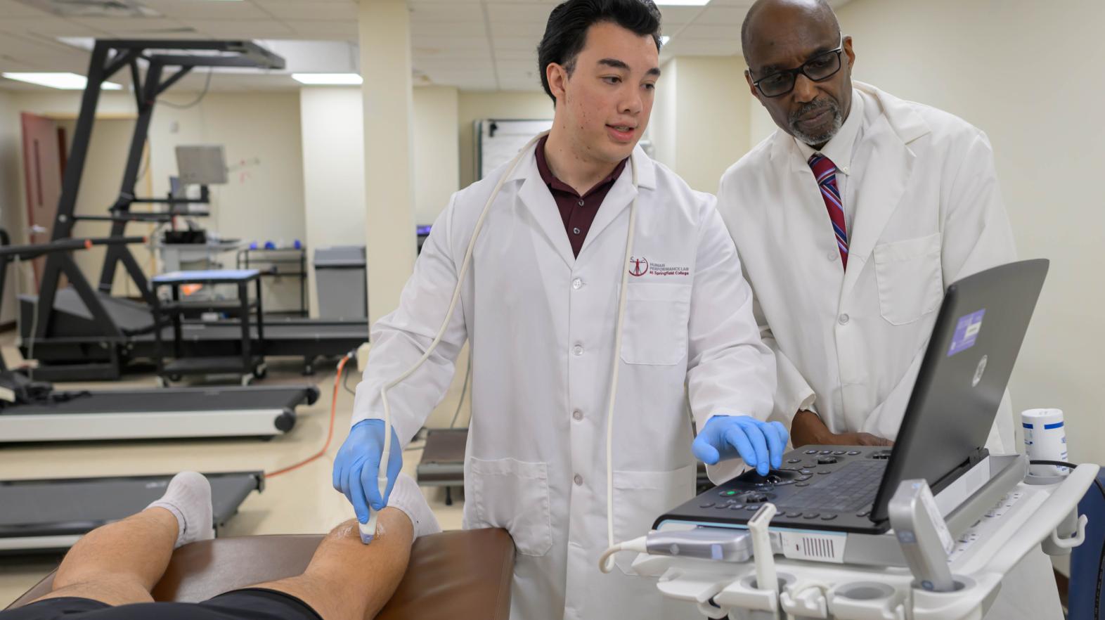 Springfield College exercise physiology graduate student Christopher Mette, left, and Professor of Exercise Science Samuel A.E. Headley work with diagnostic ultrasound machine in the Human Performance Lab on April 9, 2024.