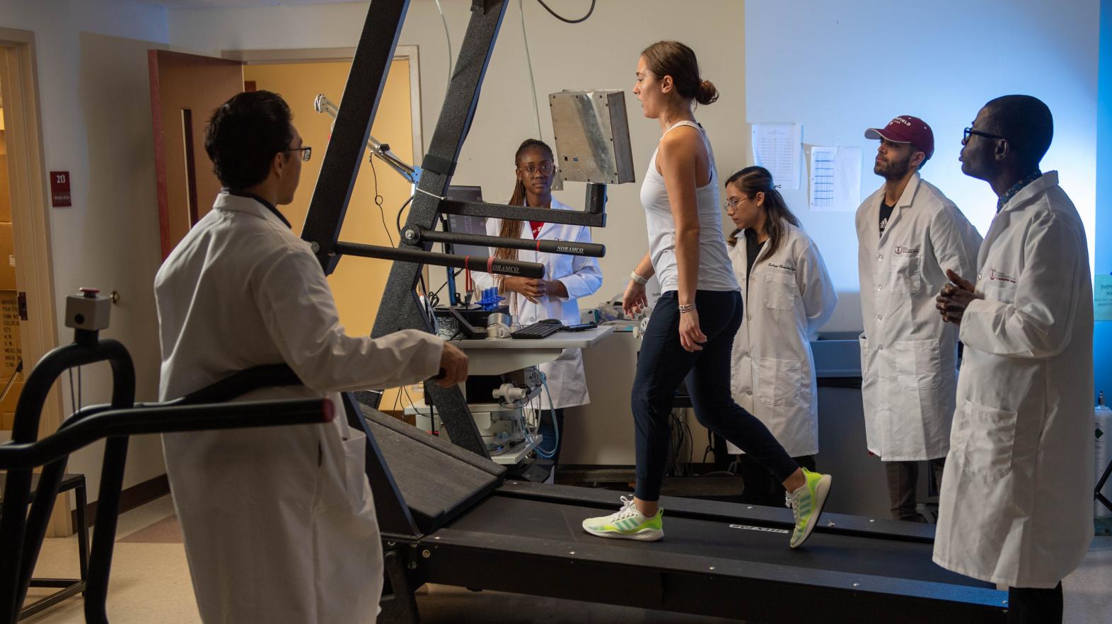 Springfield College exercise physiology doctoral and graduate student conduct a pulse rate measurement on test subject in the Human Performance Laboratory 