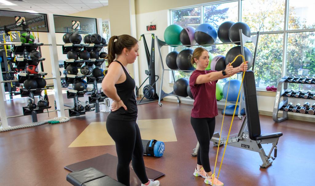 Springfield College exercise science student Kathleen Katie Beliveau works out with a classmate on October 31, 2023