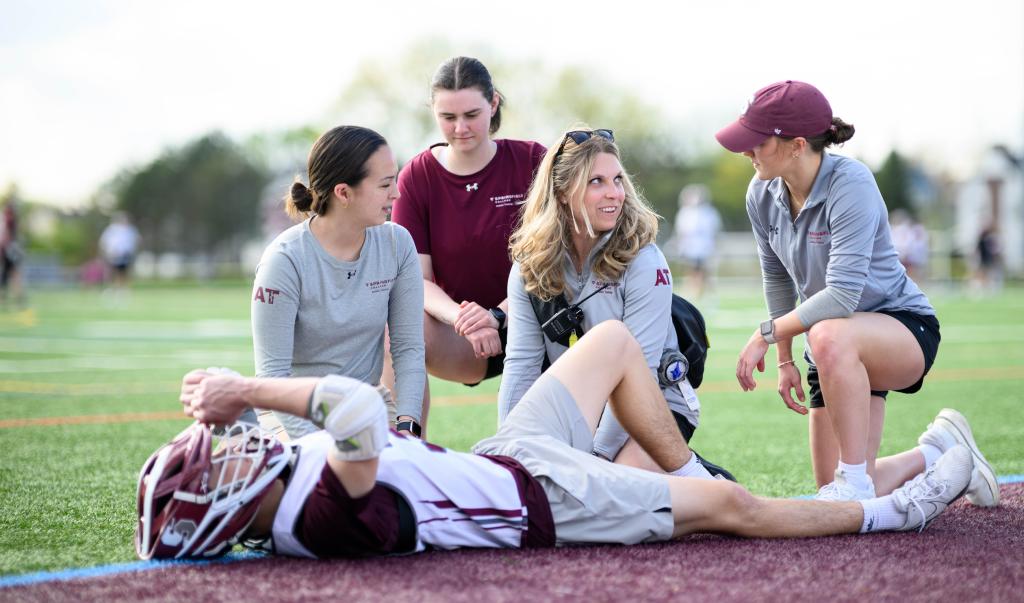 Springfield College Department of Exercise Science and Athletic Training assistant professor of Athletic Training Kelsey Rynkiewicz works with students during a men’s lacrosse practice on May 1, 2024.