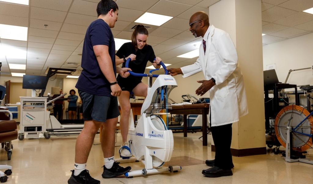 Students in sport science on Exercise bike with teacher