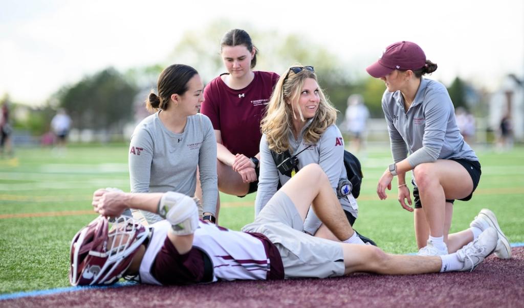 Springfield College Department of Exercise Science and Athletic Training assistant professor of Athletic Training Kelsey Rynkiewicz works with students during a men’s lacrosse practice on May 1, 2024.