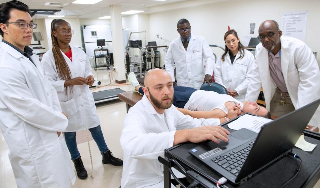 Exercise physiology students working in lab on patient