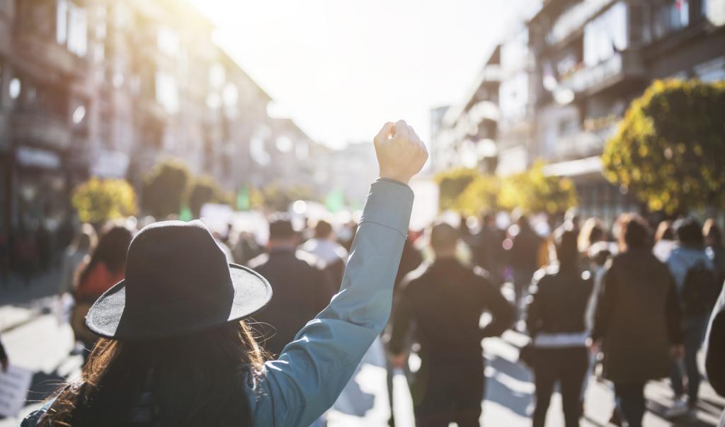 Young woman with a raised fist protesting in the street