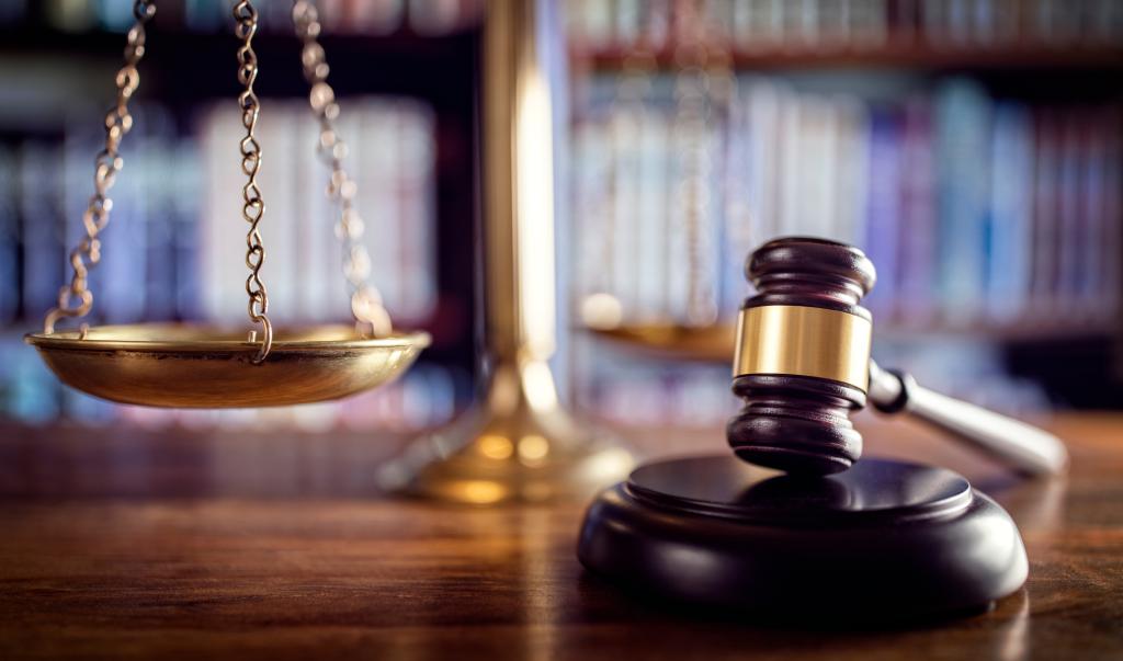 Judge gavel, scales of justice and law books in court