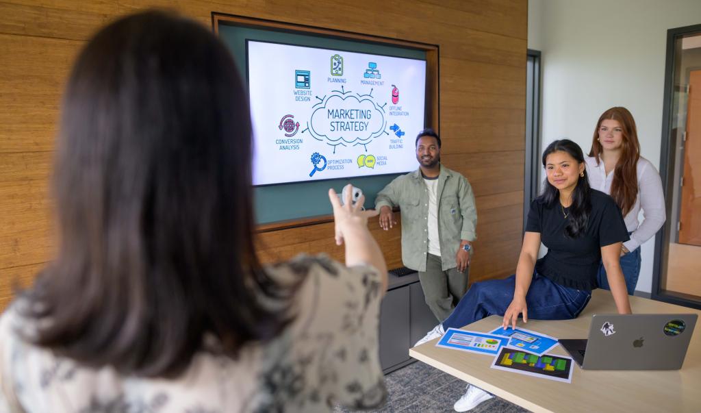 A Springfield College Business Management student uses a smartphone and ring light for video calls and social media streams on May 06, 2026.