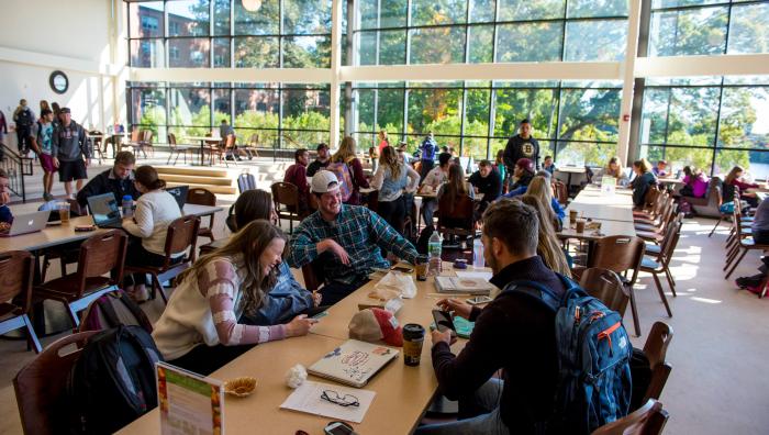 Students sit at tables in the Campus Union. 
